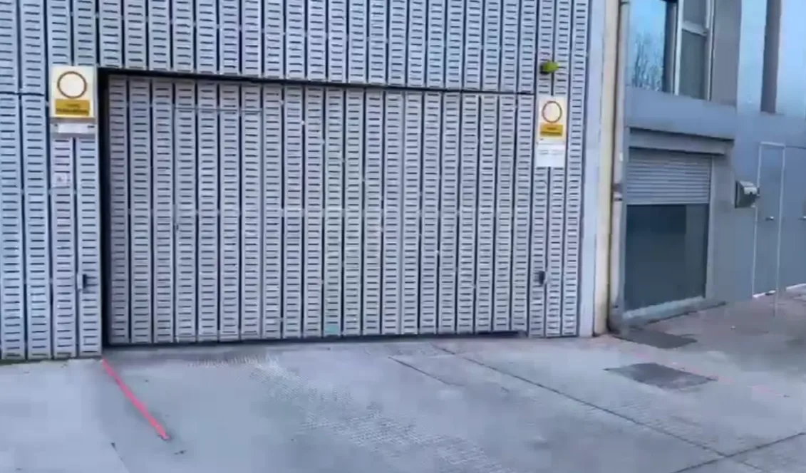 Puerta metálica de garaje y baliza LED sobre el pavimento