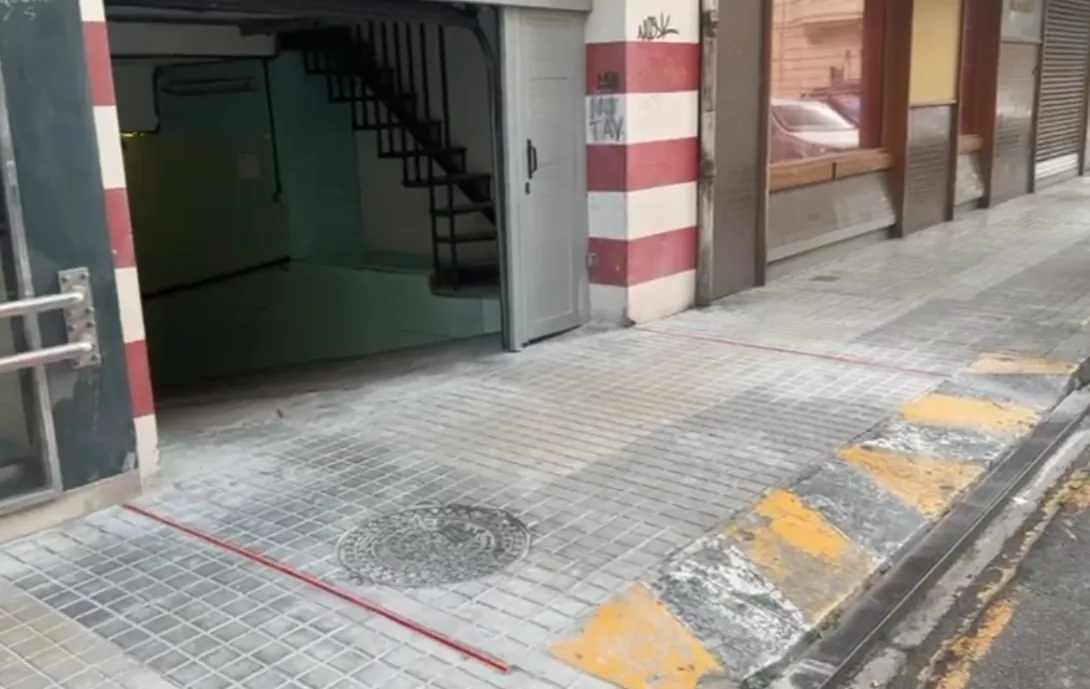 Garaje urbano con baliza luminosa junto a la acera