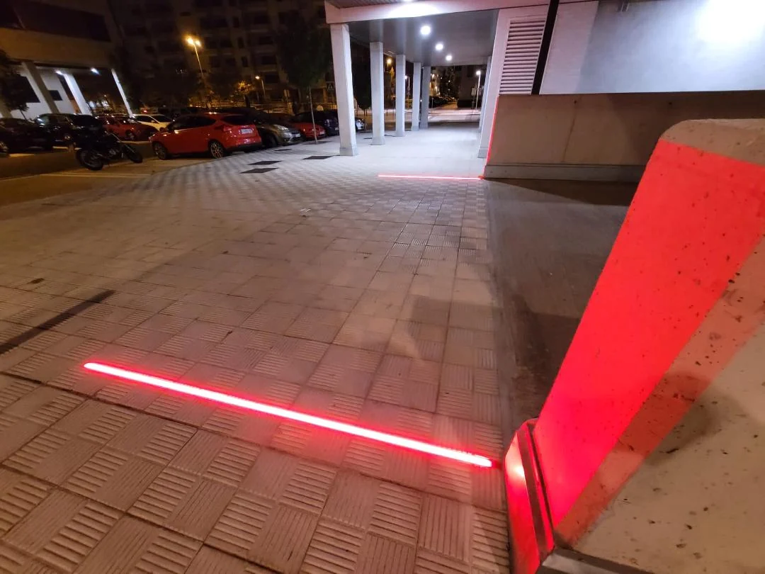 Baliza roja iluminada en una salida de aparcamiento de noche